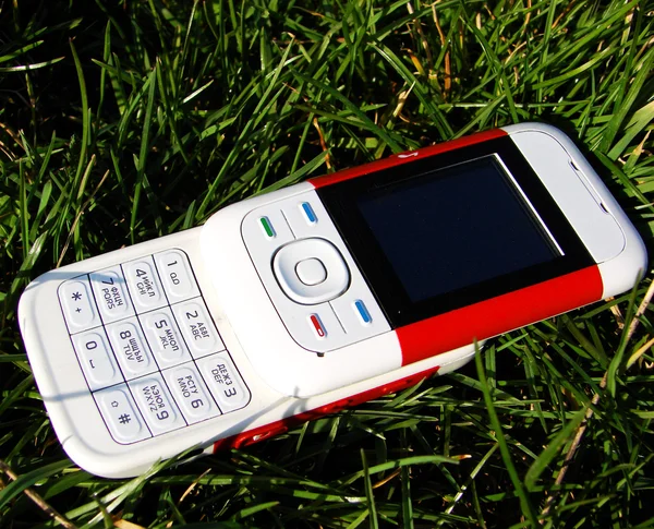 Handy liegt im Gras — Stockfoto