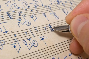Hand with pen and music sheet clipart
