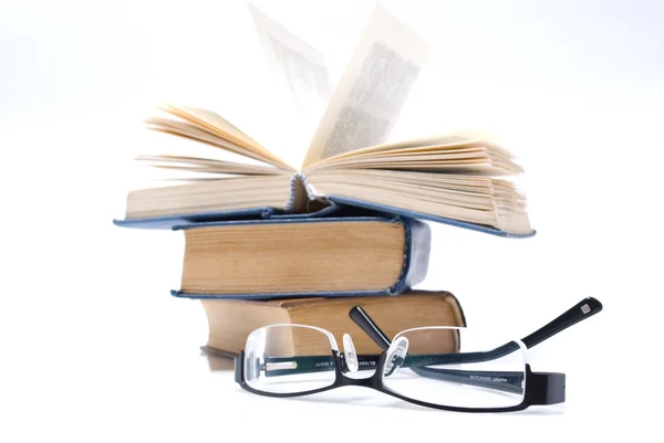 Óculos e livros sobre o fundo branco — Fotografia de Stock