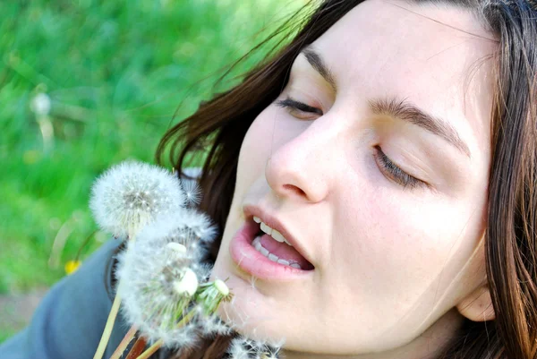 Girl is blowing on dandelion — Stok Foto