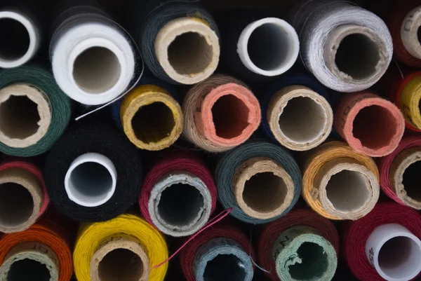 Många färgade bobiner av tråd — Stockfoto