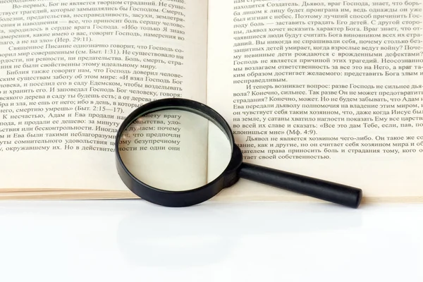 Stock image Magnifying glass and a book.