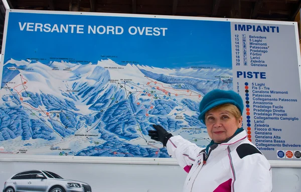 stock image Woman shows the slopes of the resort map