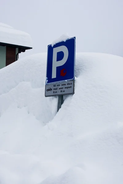 到停车场雪覆盖着的蓝色标志 — 图库照片