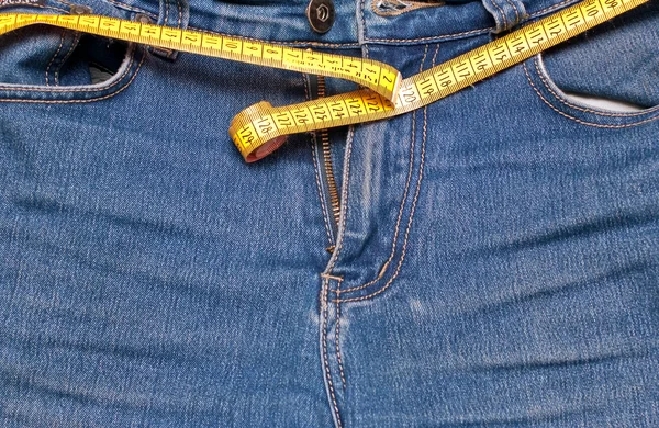 Conceito de jeans e um alfaiate medidor — Fotografia de Stock
