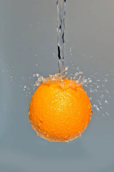 Oranžová ve vzduchu na šedém pozadí — Stock fotografie