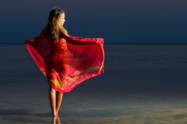 Kobieta w czerwonym na plaży — Zdjęcie stockowe