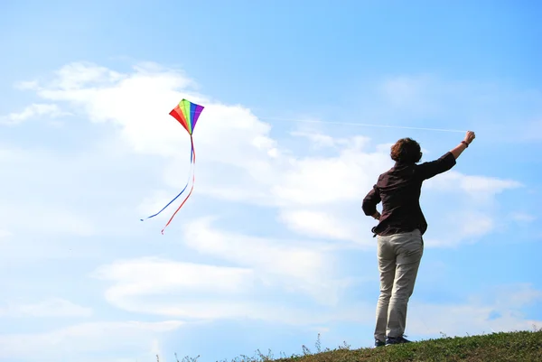 Jovem mulher mantém um kit colorido voador — Fotografia de Stock