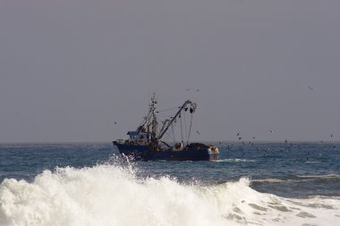 Trawler with surf wave in the foreground