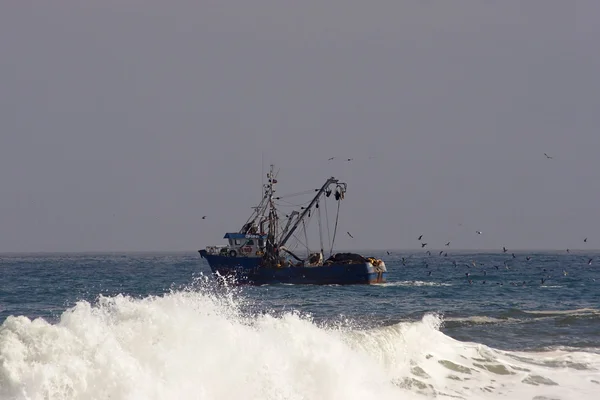 Trawler with surf wave in the foreground — Stock Photo, Image