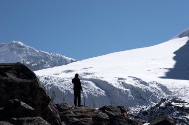 Climber looking at mountain slope, Himalaya, Nepal clipart