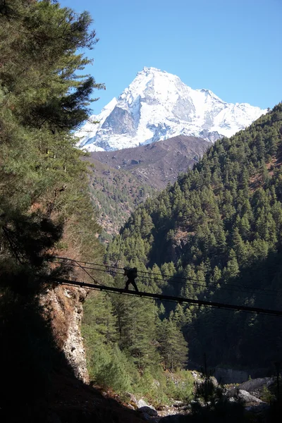 Porter crossing rope bridge at Everest trail in Himalaya, Nepal — Stock Photo, Image