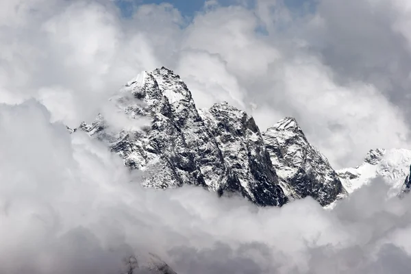 Rocky summit sticking out of clouds, Himalaya, Nepal Royalty Free Stock Photos