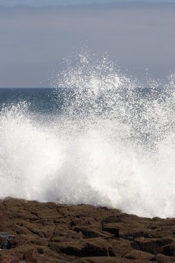 Wave crashing against the shore clipart