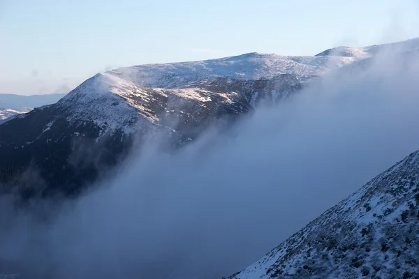 Облака на зимних склонах гор — стоковое фото