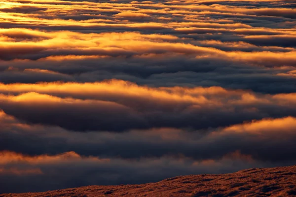 Vista montanha de nuvens douradas ao pôr do sol — Fotografia de Stock