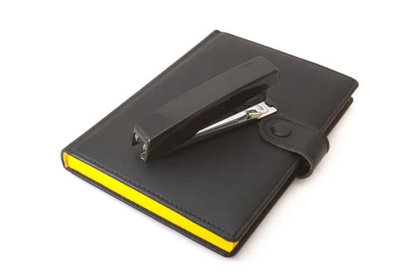 Black diary (notebook) and black stapler Stock Photo