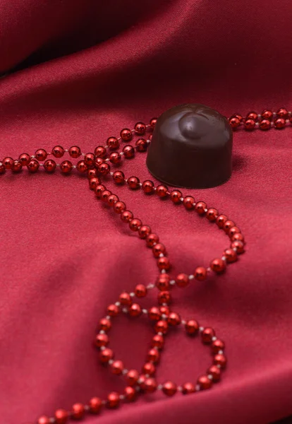 Çikolata ve kırmızı boncuklar — Stok fotoğraf
