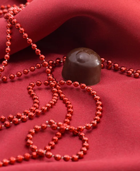 Schokolade und rote Perlen — Stockfoto