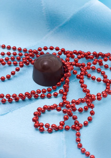 Шоколад и красные бусины — стоковое фото