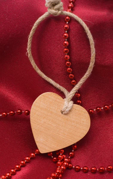 Wooden heart and red beads — Stock Photo, Image