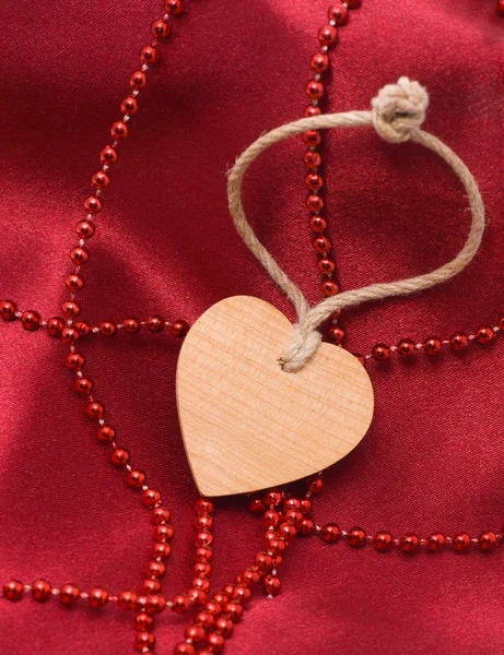 Ahşap kalp ve kırmızı boncuklar — Stok fotoğraf