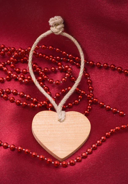 Trä hjärta och röda pärlor Stockfoto