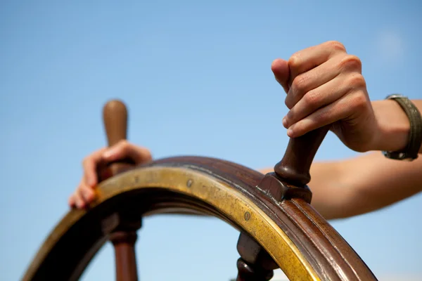 Hand on ship rudder. Royalty Free Stock Images