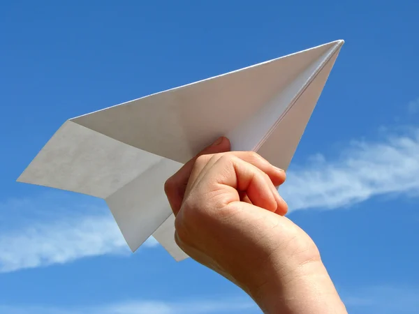 Детская рука с бумажным самолетом — стоковое фото