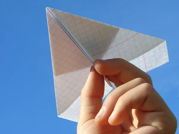 Kind hand met papier vliegtuig — Stockfoto