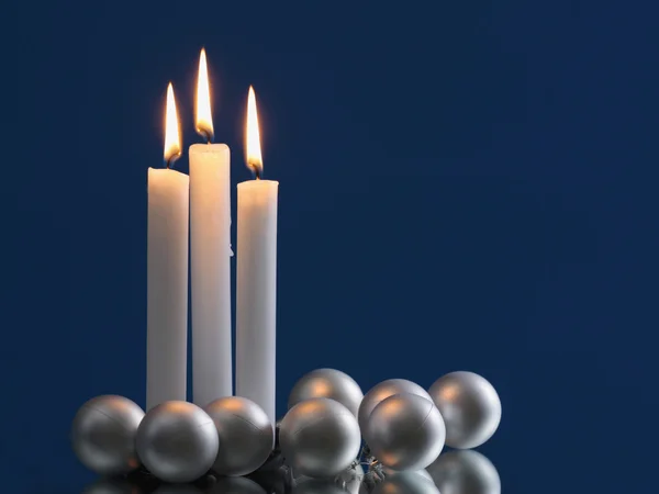 Christmas balls and burning candles — Stock Photo, Image