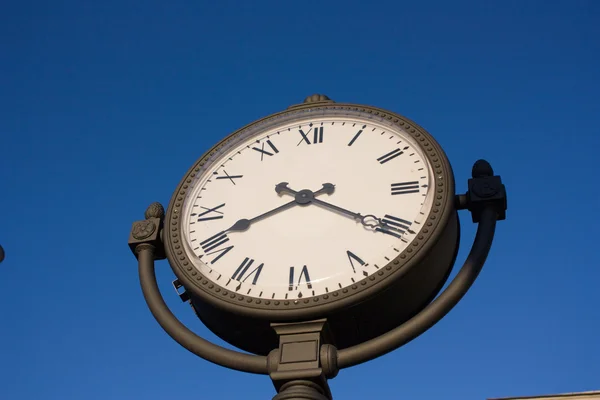 Часы на фоне голубого неба — стоковое фото