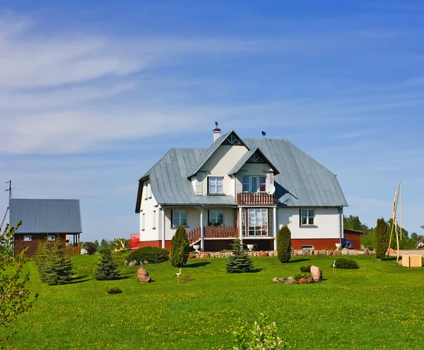 Будинок, газон, блакитне небо — стокове фото