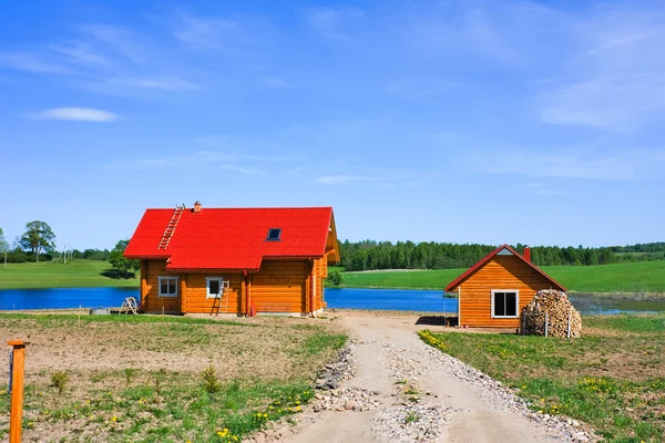 Casa de campo, lago, céu azul — Fotografia de Stock