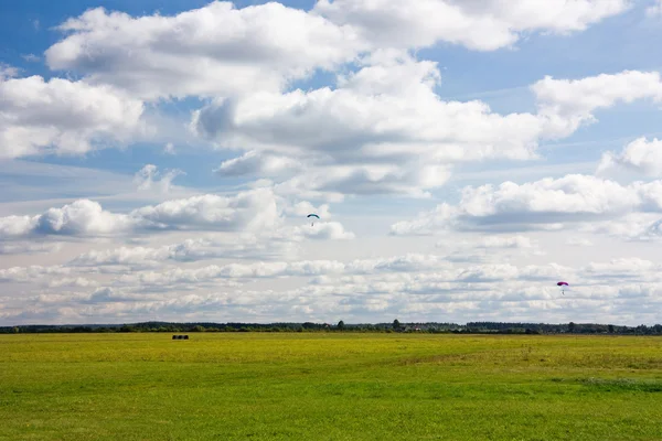 Skydivers land on the meadow — Stock Photo, Image