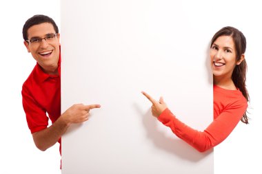 Happy couple pointing to copy space