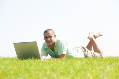 A young men on park using laptop clipart