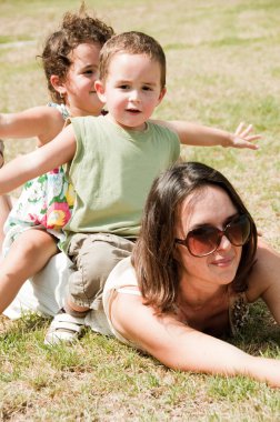 Kids sitting on the mother's back clipart