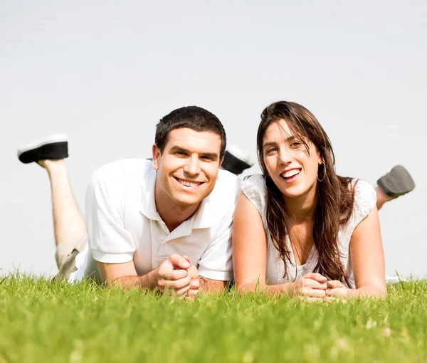 Lyckliga par Ligg ner på gräset — Stockfoto