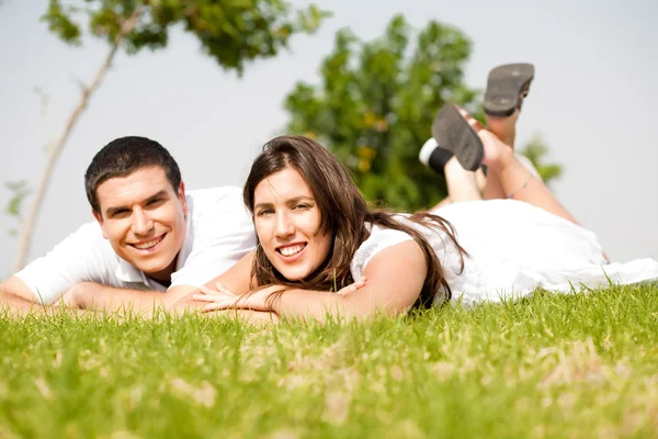 Schönes junges Paar legt sich auf Gras — Stockfoto