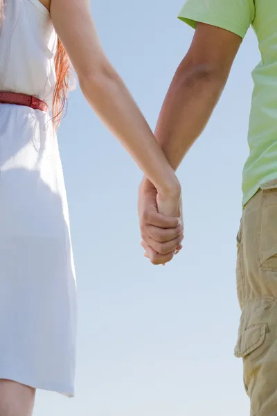 Молодая пара, держащаяся за руки — стоковое фото