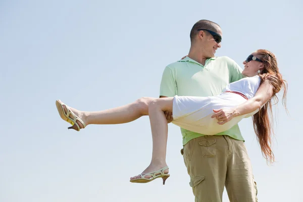 Jovem cara carregando seu namorada — Fotografia de Stock