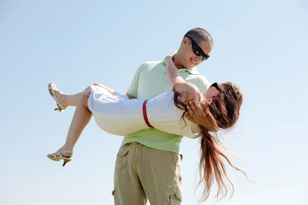 Jovem cara carregando seu namorada — Fotografia de Stock