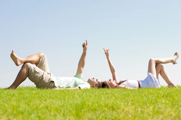 Couple lie down on grass — Stock Photo, Image