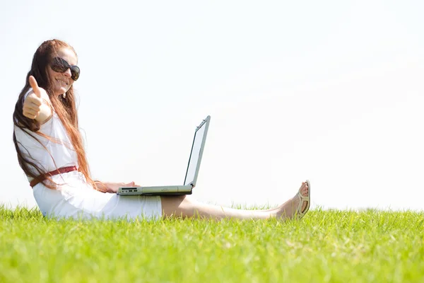 一名年轻女子在公园使用的便携式计算机上 — 图库照片