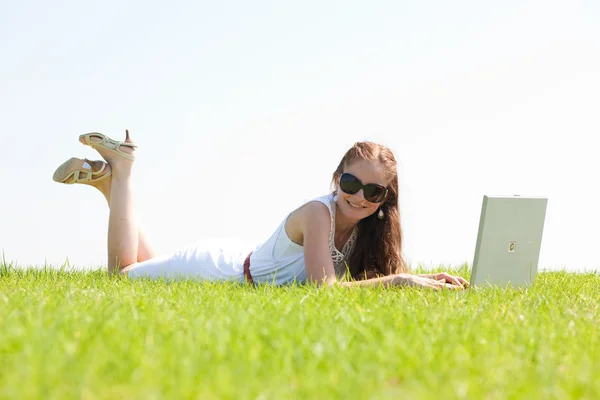 Een jonge vrouw op park met behulp van laptop — Stockfoto