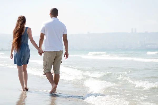 年轻夫妇走在沙滩上 — 图库照片