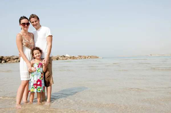 年轻家庭站在海滩 — 图库照片