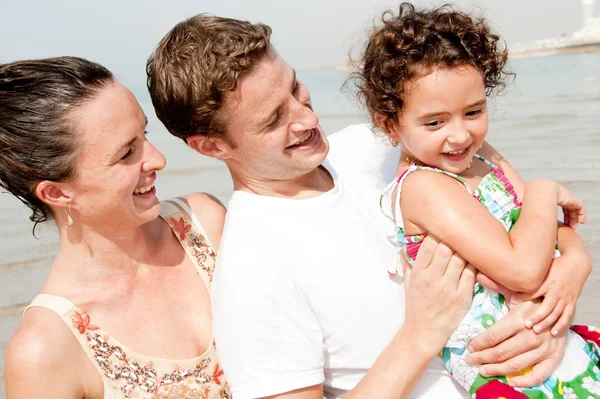 Ouders en kind lacht in het strand — Stockfoto