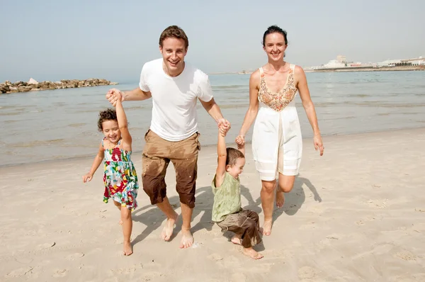 Barn med föräldrar i beach — Stockfoto